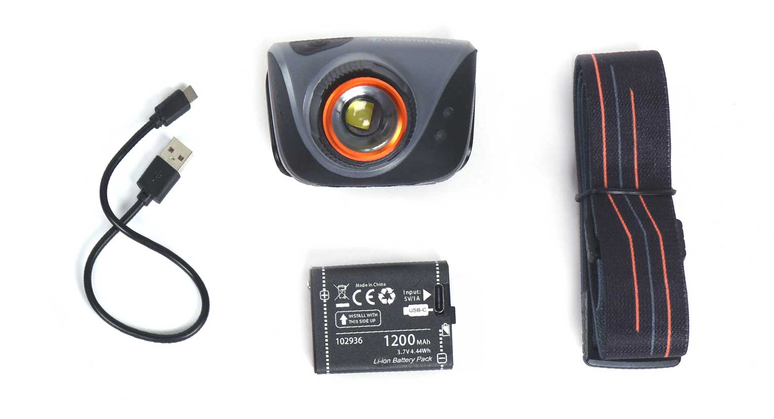 Lifesystems Intensity 580 head torch components laid out, including the torch unit with orange trim, USB charging cable, 1200mAh lithium-ion battery pack, and folded adjustable head strap with orange detailing.
